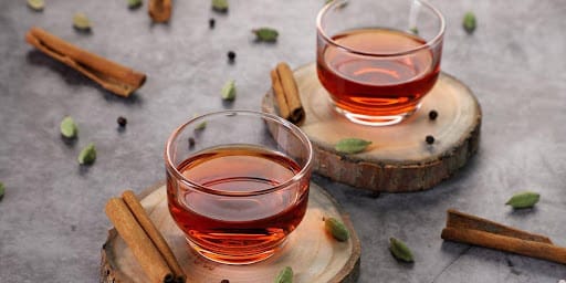 Chá em cima da mesa com alguns pedaços de canela