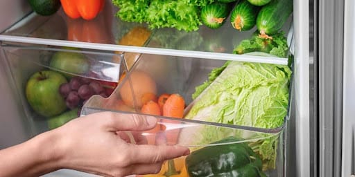 Legumes sendo guardados na geladeira