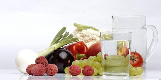 Mesa com diversas frutas e jarra de água