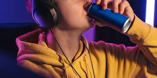 Homem com moletom amarelo tomando energético